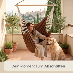 Brauner AMANKA Hängesessel aus Baumwolle, Frau entspannt mit Hund auf Balkon. Ideal als Schwebesessel, bis 150 kg belastbar.