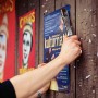 Rapid Hammertacker R19 beim Anbringen eines Posters an einer Holzwand.