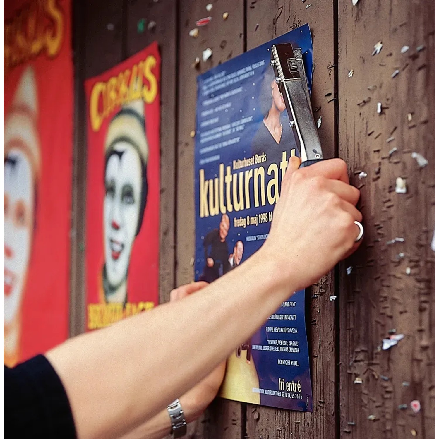 Rapid Hammertacker R19 beim Anbringen eines Posters an einer Holzwand.