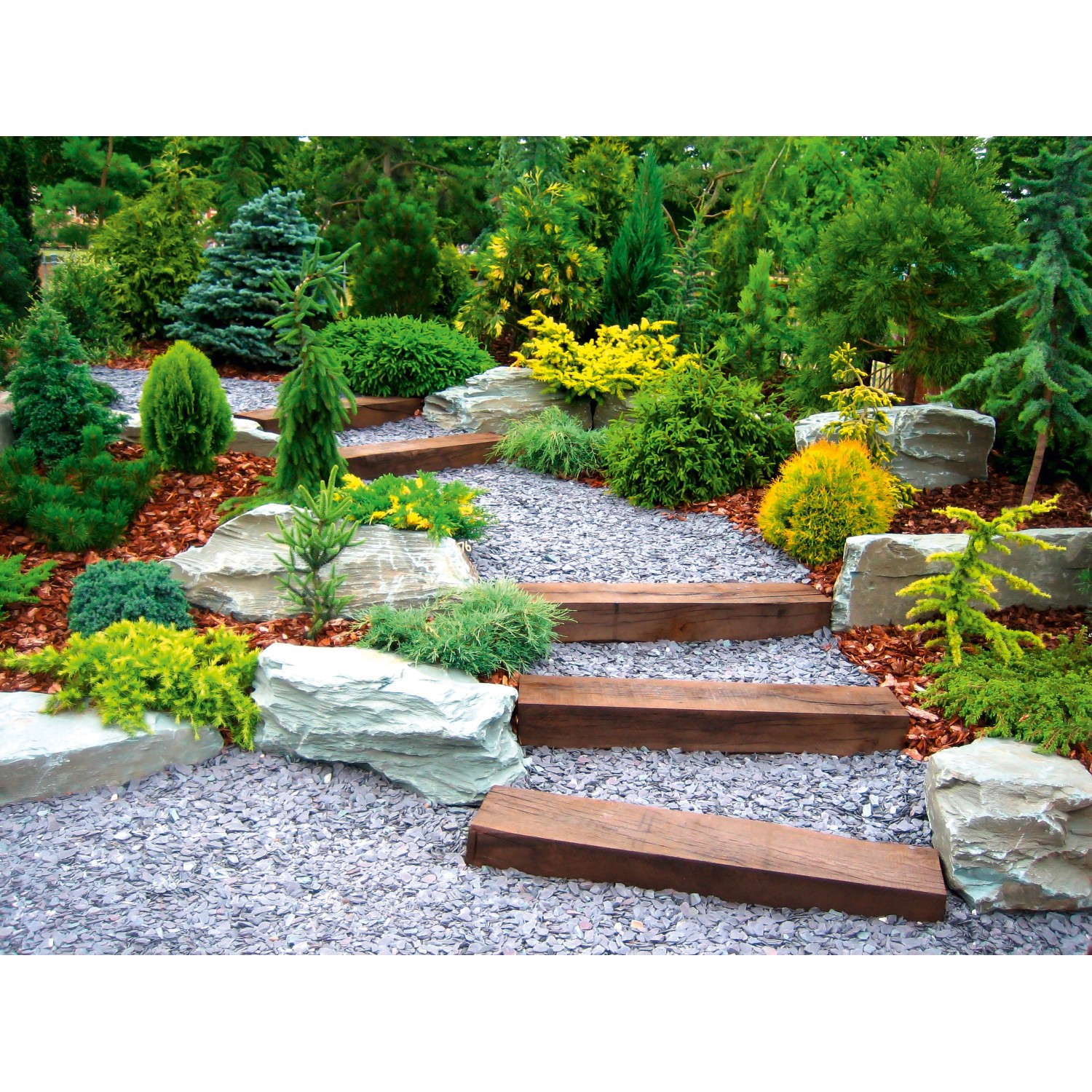 Gartenweg mit Unkrautvlies unter Kies, Holzstufen und Pflanzen.