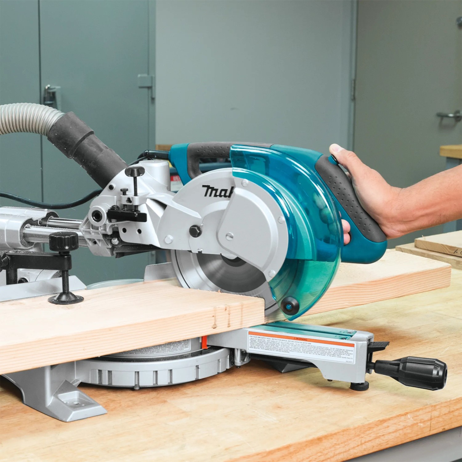 Makita LS0815FLN Kapp- und Gehrungssäge in Aktion, Werkstück wird gesägt.