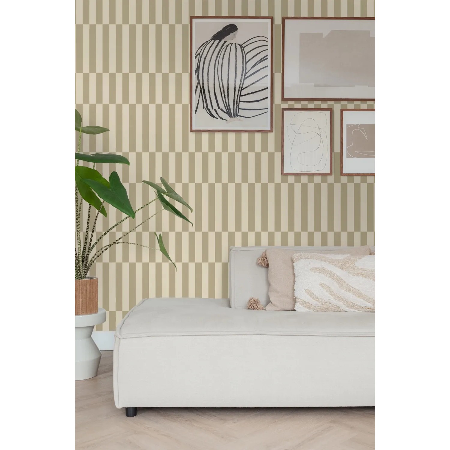 ESTAhome Vliestapete mit beigebraunen Streifen an einer Wand, daneben ein weißes Sofa und eine Pflanze.