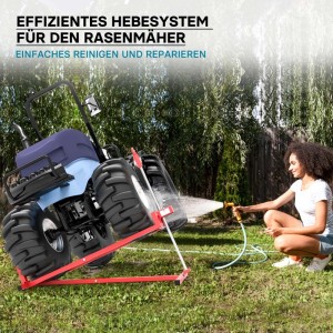 Rote Wiltec Hebevorrichtung kippt blauen Aufsitzmäher. Frau reinigt Unterseite mit Wasserschlauch. Ideal für Rasentraktor Wartung.