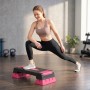 Frau trainiert auf SPORTNOW Aerobic Stepper in Schwarz-Rosa. Höhenverstellbar, rutschfeste Oberfläche für Fitnessübungen.