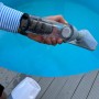Weiß-grauer Pool-Handsauger mit Akku und Ladegerät für die Poolreinigung.
