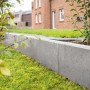 Grauer Diephaus L-Stein (50x50x30x7 cm) zur Beet- oder Böschungsbegrenzung im Garten.