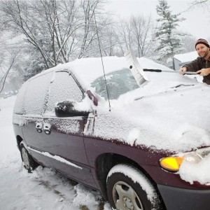 Mann räumt mit langer Costway Dach-Schneeschaufel Schnee vom Auto. Aluminium-Schneeschieber mit Gummilippe für Dächer.
