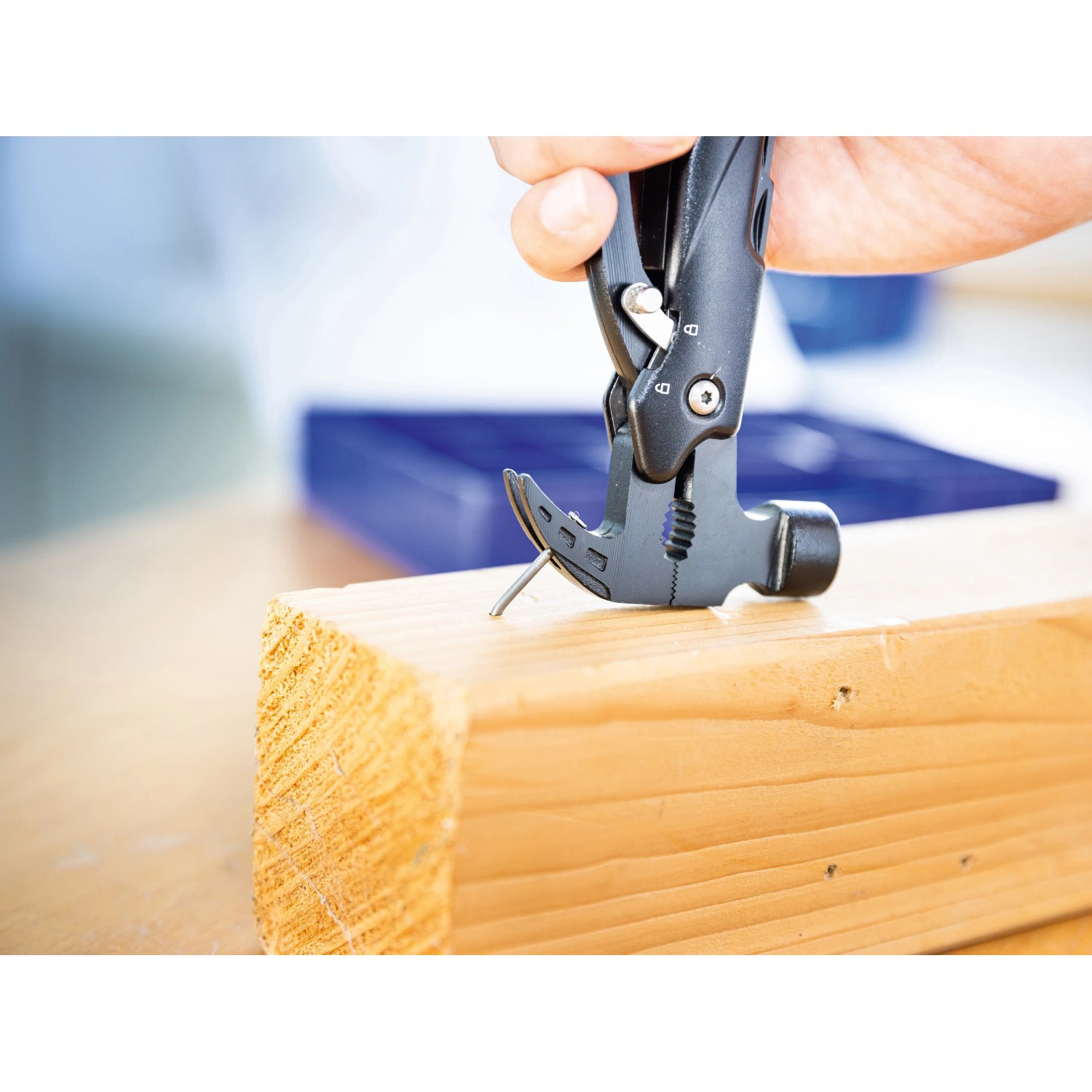 LUX Multi-Tool Hammer Messer beim Einschlagen eines Nagels in Holz.