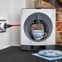 Shelly Smart-Stecker Plug S Gen3 in Weiß im Einsatz mit Kaffeemaschine in Küche.