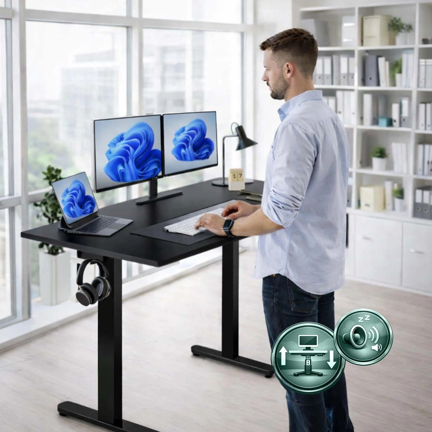 Mann steht an schwarzem, elektrisch höhenverstellbarem Schreibtisch mit Monitoren. Ergonomischer Steh-Sitztisch für Home Office.