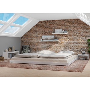 Weißes Kiefernholz Niederflurbett 180x200 mit Rollrost im Schlafzimmer mit Backsteinwand.