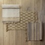Drei graue Wenko Badematten Sambu (50x80 cm) aus Jute mit Fransen auf Holzboden.