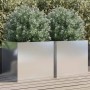 Zwei silberne, rechteckige Edelstahl Pflanzkübel mit grünen Pflanzen auf Holzterrasse. Modernes Design für Garten & Balkon.