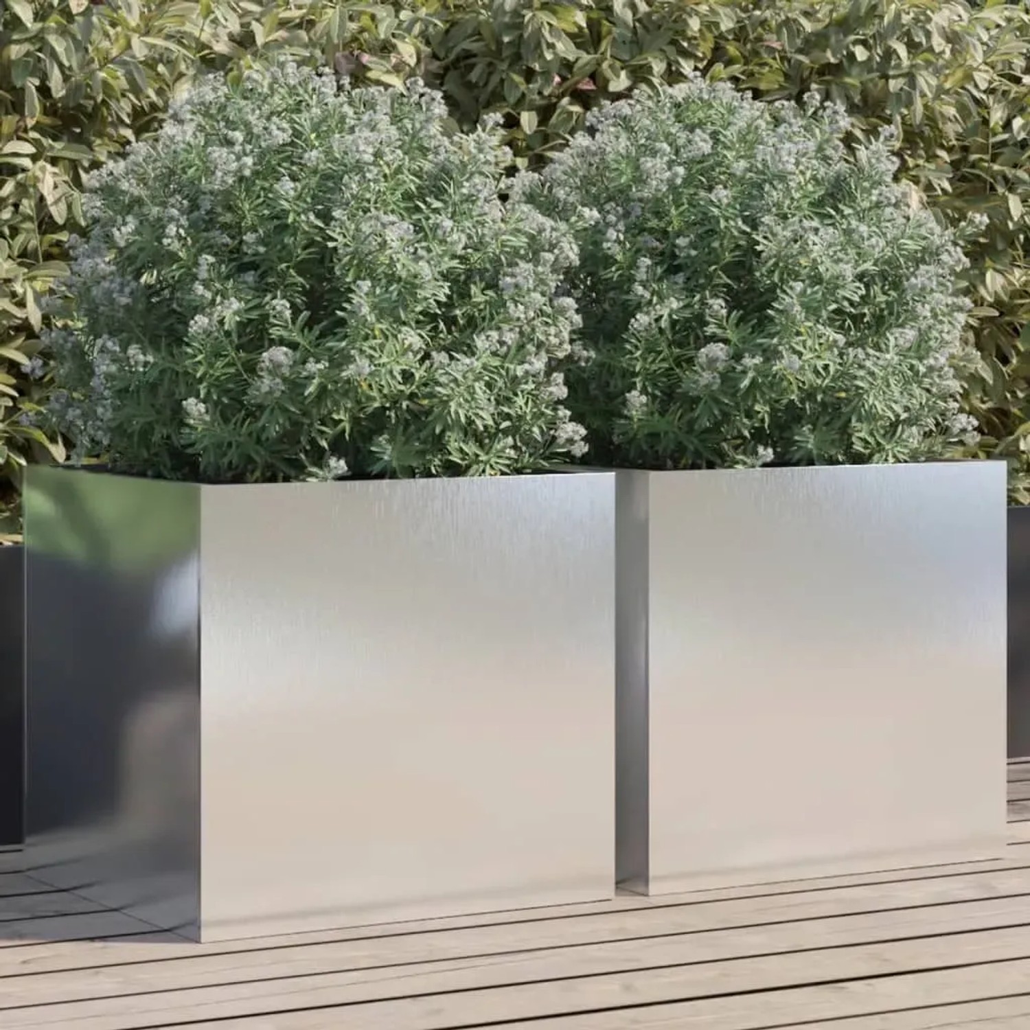 Zwei silberne, rechteckige Edelstahl Pflanzkübel mit grünen Pflanzen auf Holzterrasse. Modernes Design für Garten & Balkon.