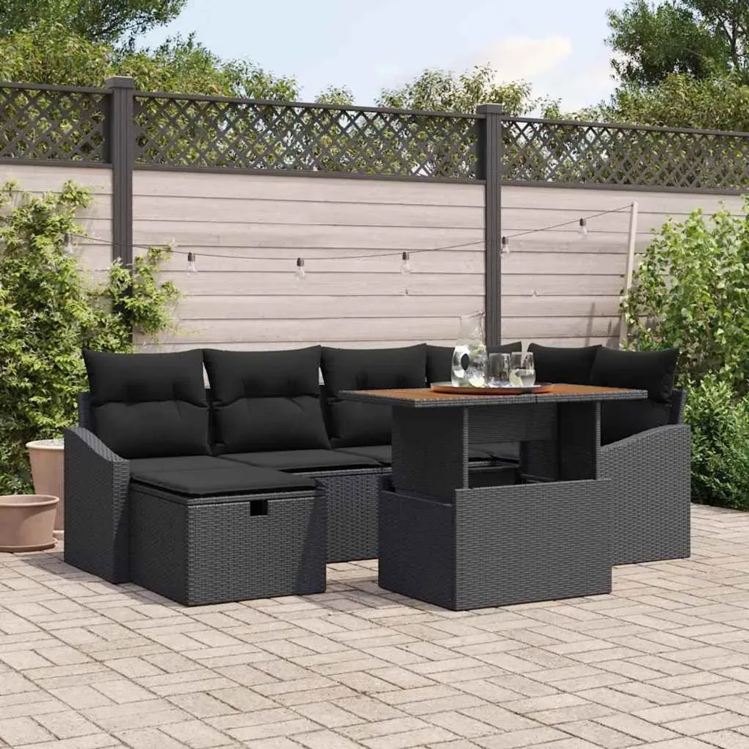Schwarzes 7-teiliges vidaXL Garten-Sofa-Set aus Poly Rattan mit Tisch und Kissen.