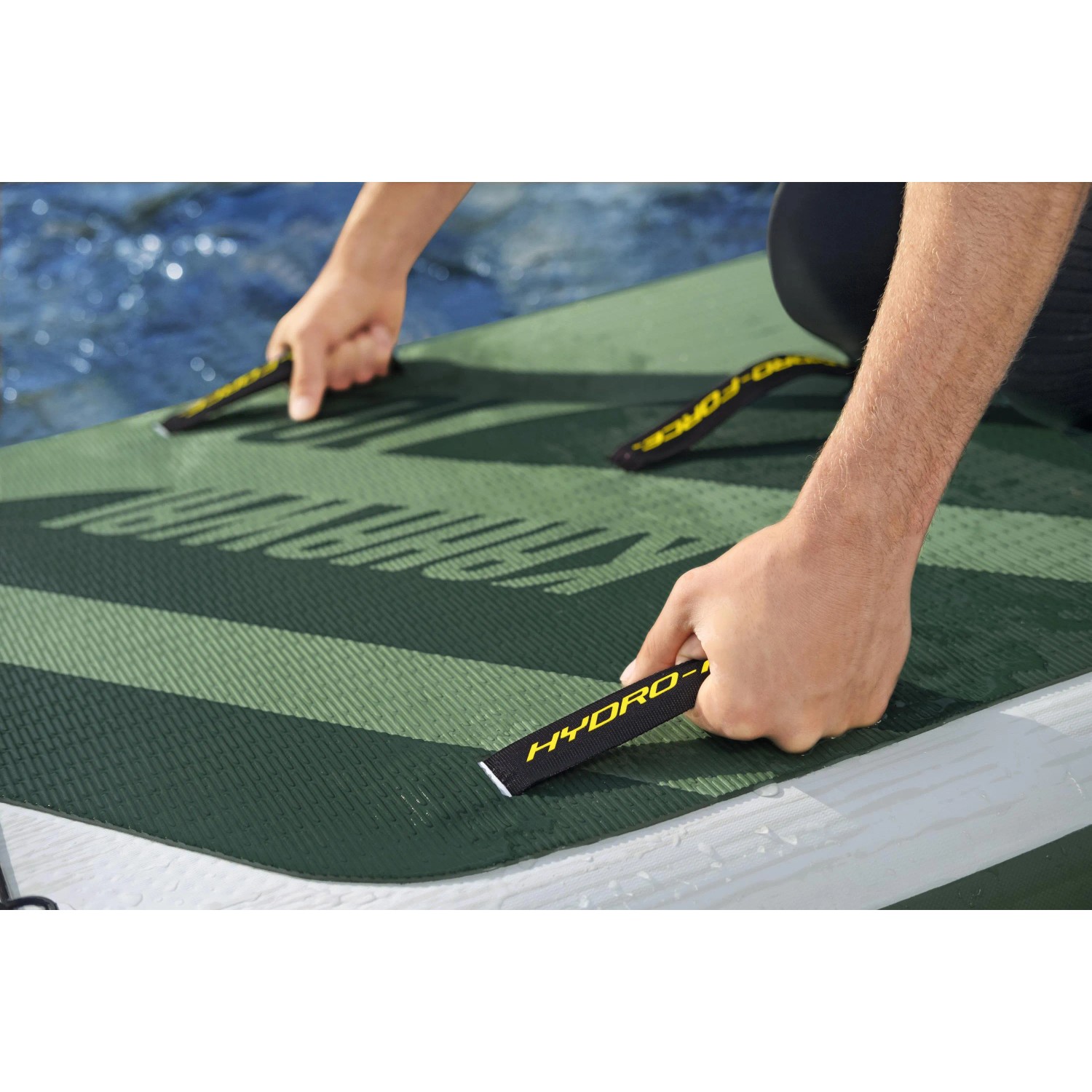 Detailaufnahme: Person befestigt Bestway Hydro-Force SUP River Board Kahawai. Grün mit Tragegriffen.