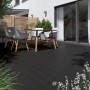 Terrasse mit anthrazitfarbenen Kovalex WPC Terrassendielen und Gartenmöbeln.