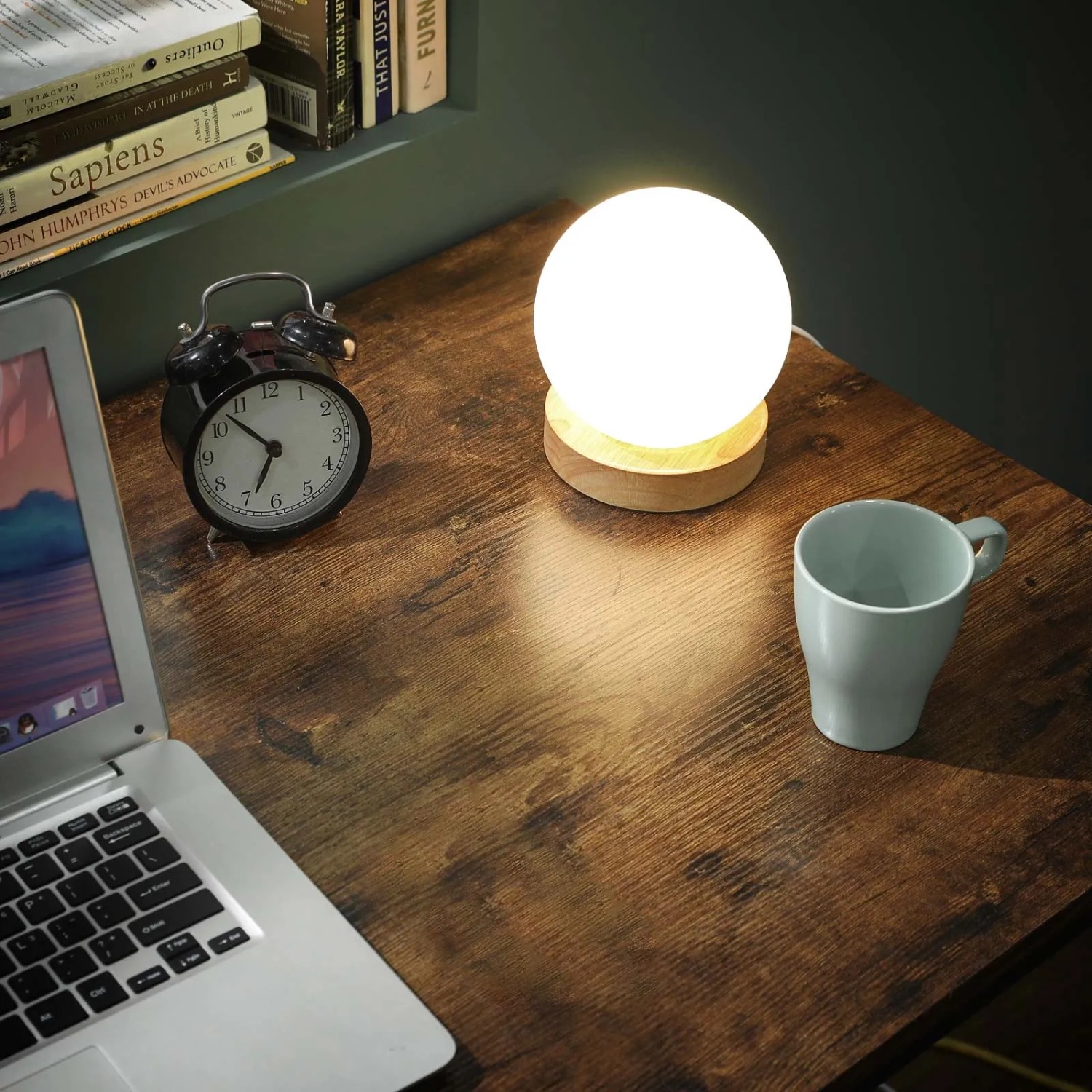Vasagle L-förmiger Computertisch in Braun-Schwarz mit Lampe, Tasse, Laptop und Uhr auf der Tischplatte.