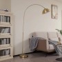 Moderne Lindby Bogenleuchte Lennart aus goldfarbenem Messing-Metall im Wohnzimmer. Elegante Stehlampe mit gewölbtem Schirm und rundem Fuß.