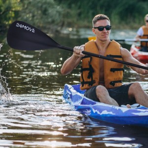 Mann paddelt mit 24Move Doppelpaddel im Kajak auf dem Wasser. Sport & Fitness.