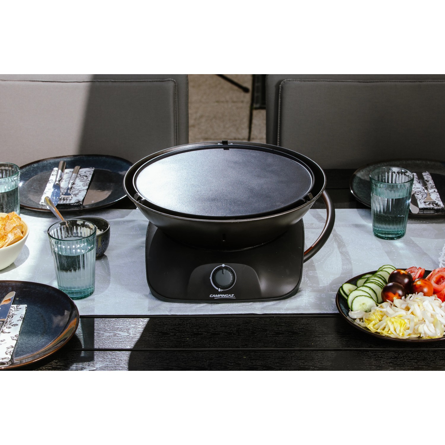 Campingaz 360° Tisch-Grill CV Anthrazit auf Tisch mit Speisen.