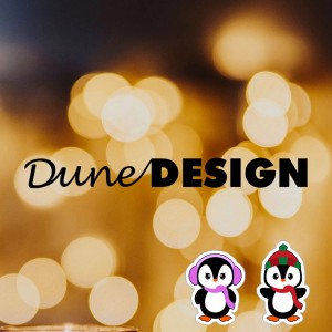 DuneDesign DIY Adventskalender mit Logo und Pinguin-Aufklebern vor Bokeh-Lichtern.
