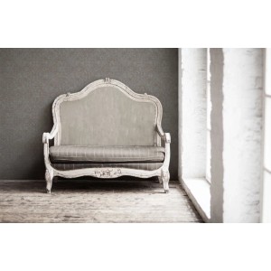 Livingwalls Vliestapete Ethnische Motive Grau hinter antikem Sofa vor Fenster.