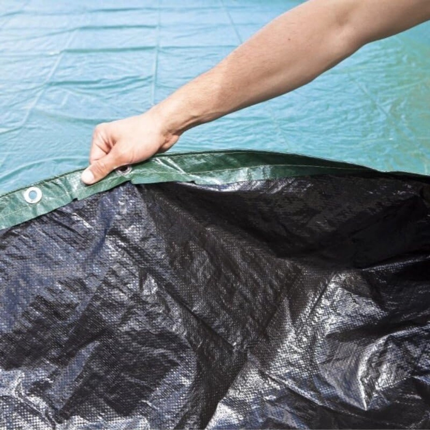 Detailansicht der Poolomio Winterplane (800x400 cm) für ovale Pools, grün/schwarz, mit Befestigung.