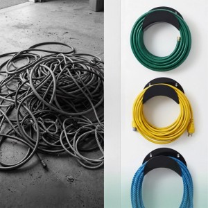 Drei Wand-Schlauchhalter aus Eisen mit aufgerollten Schläuchen, daneben ein Haufen unordentlicher Kabel. Ordnung für Garten & Garage.
