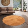 Runder, terrakottafarbener Fellteppich „Pergamon Luxus Super Soft“ (120x120cm) im Wohnzimmer.