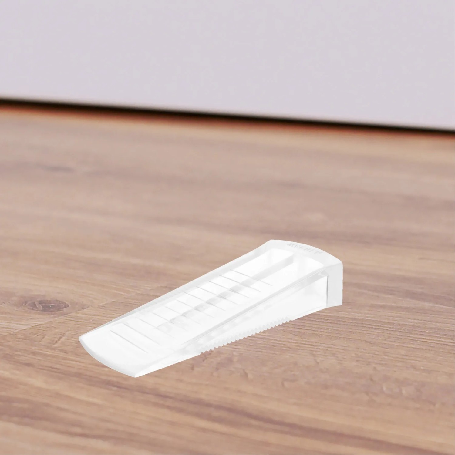 Transparenter Wagner Türkeil Standard aus Kunststoff (80x30x15mm) auf Holzboden.