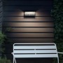 Moderne Philips myGarden LED-Außenwandleuchte Bustan mit Bewegungsmelder an dunkler Hauswand.