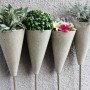 Vier bepflanzte, hellgraue Ultrament Bastel Beton Kegel als Deko für den Garten oder die Wohnung.