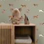 ESTAhome Vliestapete mit braunen und grünen Hundemotiven an einer grünen Wand im Kinderzimmer.