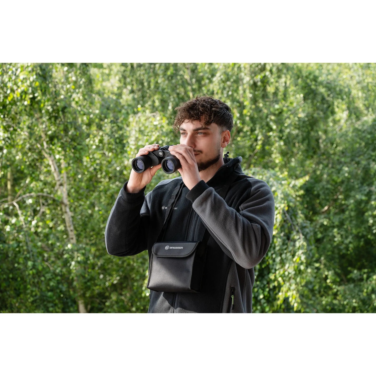 Mann mit Bresser Hunter 8x40 Fernglas in Schwarz bei der Beobachtung in der Natur.