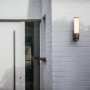 Moderne Lutec LED-Außenwandleuchte Leda mit Bewegungsmelder an grauer Hauswand.