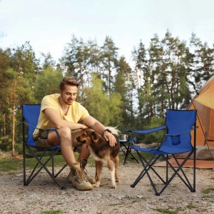 Blauer Sunula Campingstuhl mit Mann und Hund im Grünen. Faltbarer Anglerstuhl mit Getränkehalter.