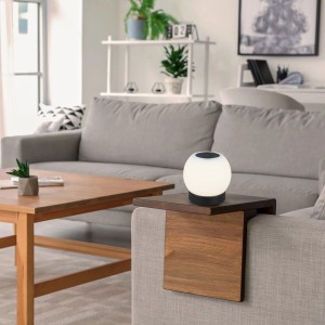 Brilo Akku-Tischleuchte Poka, schwarz, auf einem Sofa-Arm, für gemütliche Beleuchtung im Wohnbereich.