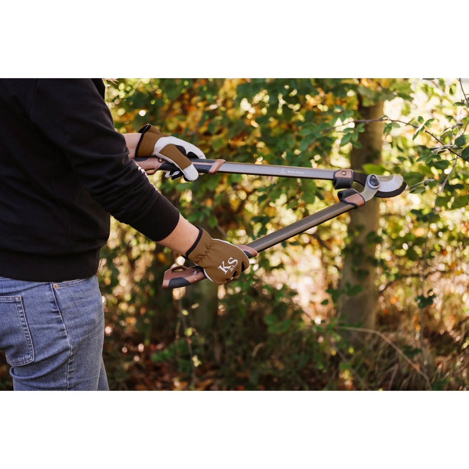 Person mit Kent & Stowe Gartenhandschuhen Sure & Fit M beim Schneiden von Ästen.