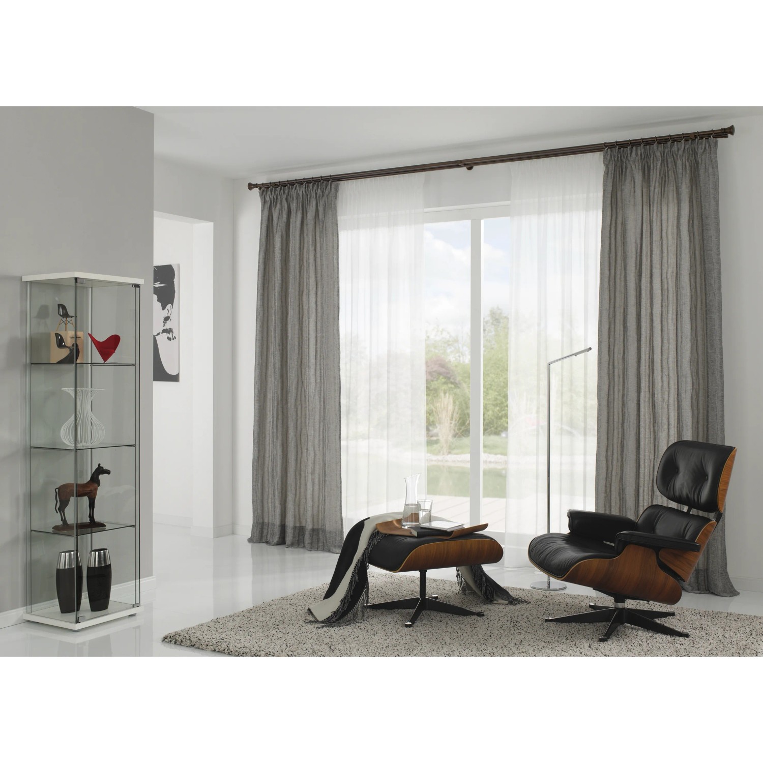 Gardinia Gardinenringe Windsor Bronze, 10er-Pack, an einer braunen Gardinenstange mit grauen Vorhängen.