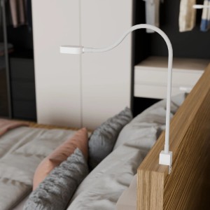 Weiße kalb Ilios LED-Bettleuchte mit flexiblem Arm und USB-C Anschluss am Bett befestigt.