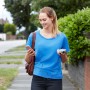 Frau nutzt Black+Decker USB-Akku 12V zum Laden ihres Smartphones unterwegs.
