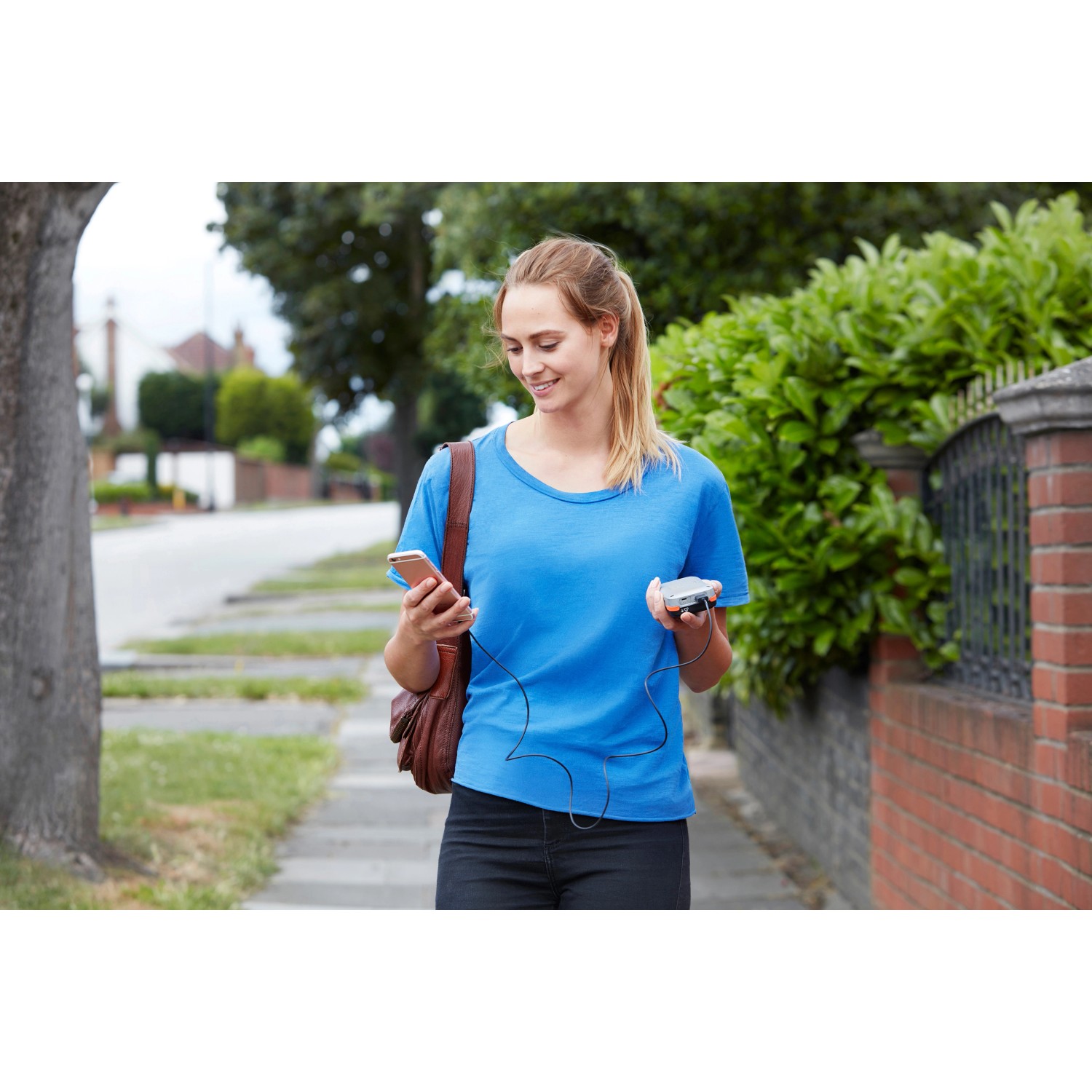 Frau nutzt Black+Decker USB-Akku 12V zum Laden ihres Smartphones unterwegs.