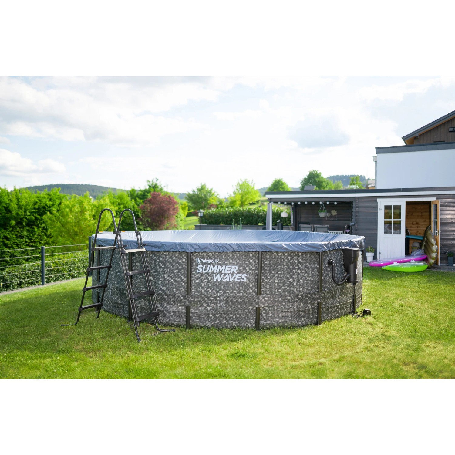 Summer Waves Rundpool 488 cm in Rattangrau mit Leiter im Garten.