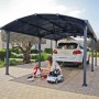 Canopia Carport Arcadia 6400 in Anthrazit mit Auto und spielenden Kindern.