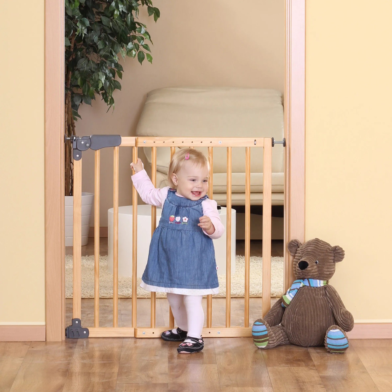 Reer Basic Klemm- und Schraubgitter aus Holz, Breite 730-1045mm, mit Kind und Teddybär vor Türrahmen.
