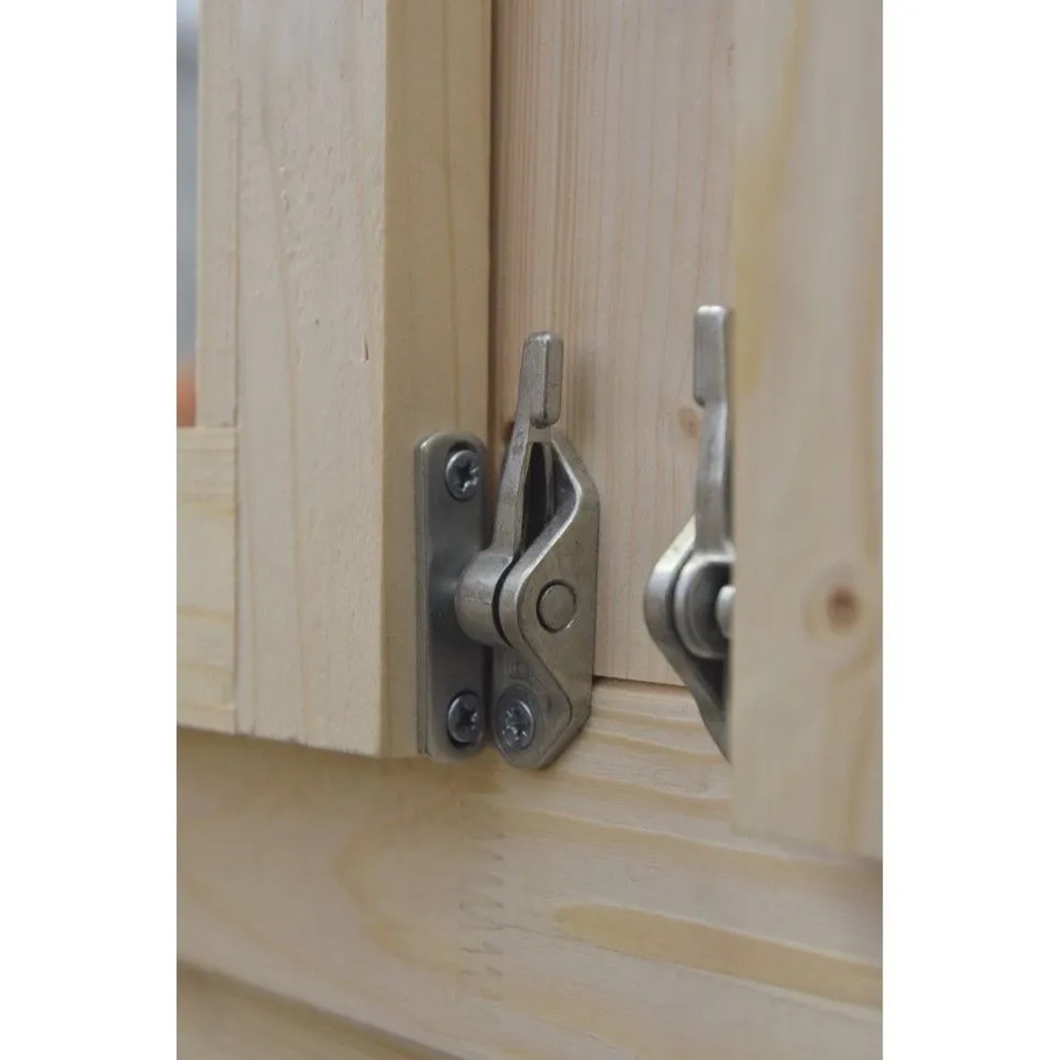 Detailaufnahme: Fensterriegel aus Metall an einem Holz-Gartenhaus.