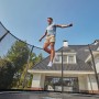 Schwarzes Salta Trampolin First Class (ø 366 cm) mit Sicherheitsnetz und springender Person.