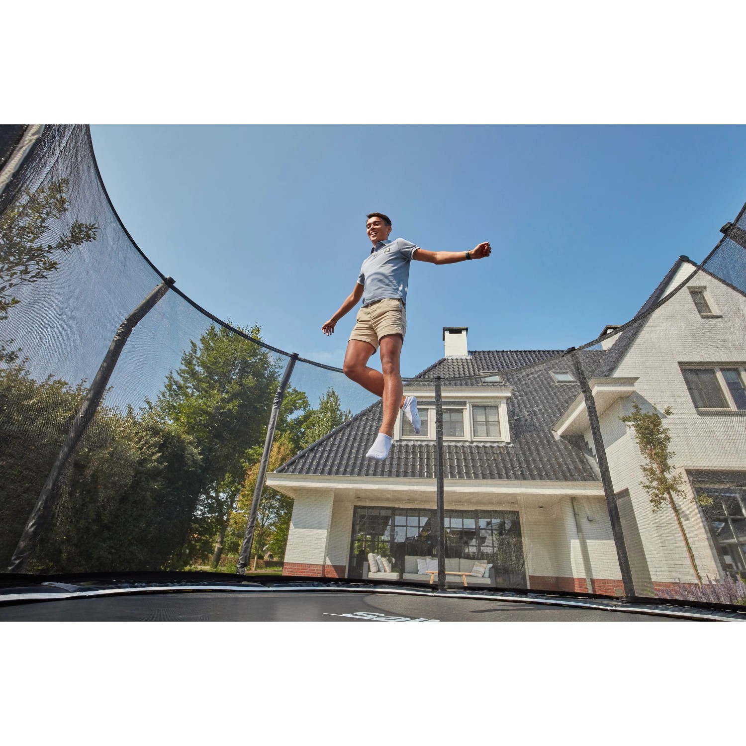 Schwarzes Salta Trampolin First Class (ø 366 cm) mit Sicherheitsnetz und springender Person.