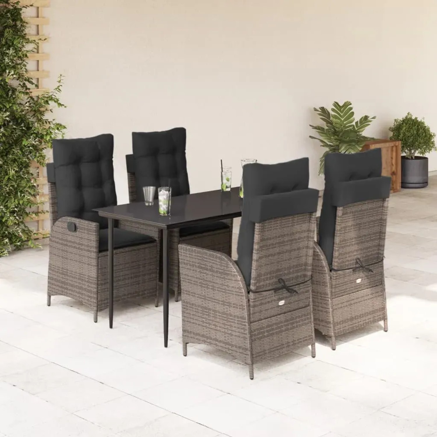 5-teilige Garten Essgruppe aus grauem Poly Rattan mit schwarzen Kissen.